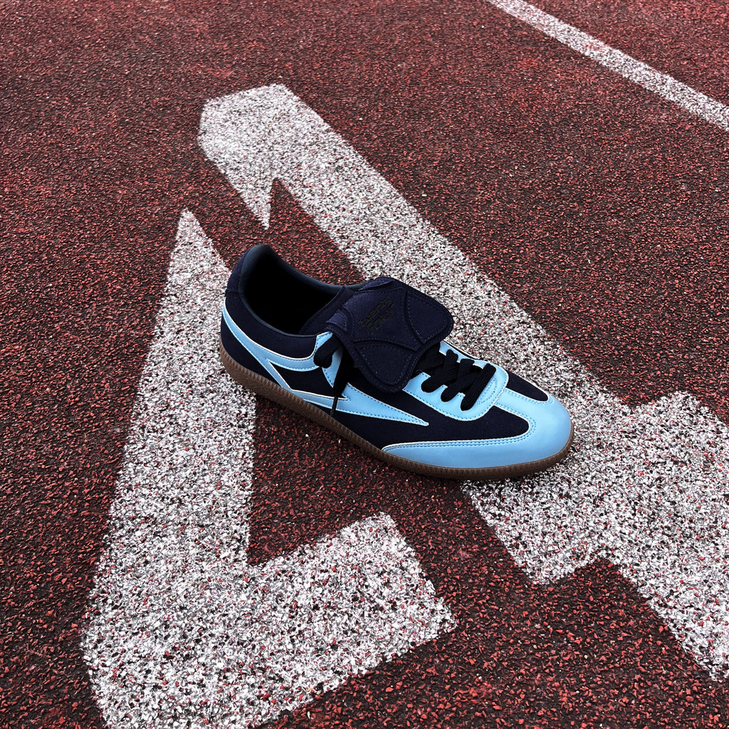 Marineblauer twentyfourdegree Sneaker aus Apfelleder, hellblaue Akzente, auf roter Laufbahn